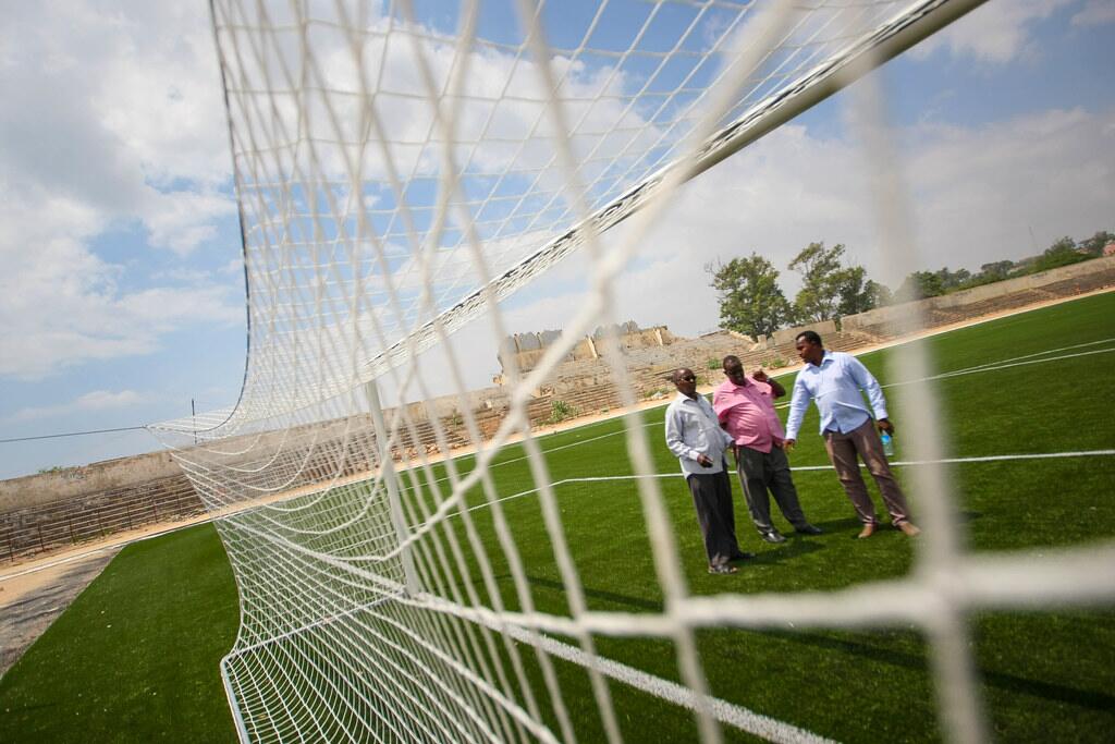 Synthetic football turf seen through a goal net